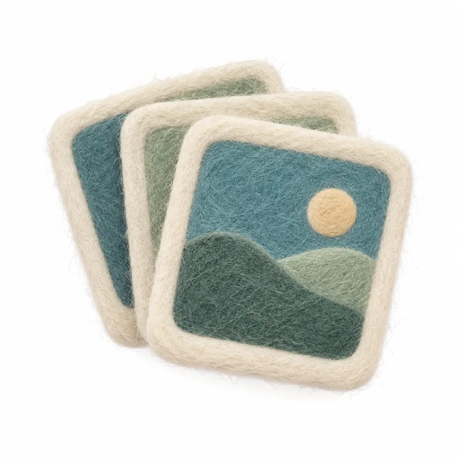 Three overlapping felt photo cards, the front one showing teal hills and a cream sun